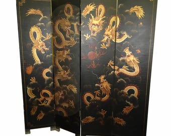 May include: Black four-panel room divider featuring gold dragons amidst clouds. The dragons have detailed scales and are painted with red accents. The divider has a rectangular shape and is supported by small feet.