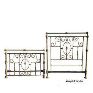 May include: Antique brass bed frame with ornate scrollwork and decorative details. The headboard and footboard feature a classic design with vertical bars and elegant curves. The bed frame is a vintage piece.