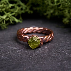 Braided Raw peridot ring. Rustic viking promise band in dark copper. Green gem forest witch crystal jewelry. August birthstone gift.