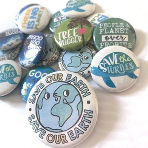 May include: A collection of round, white and blue buttons with environmental themes. The buttons feature phrases like "Save Our Earth," "Save the Turtles," and "Tree Hugger." The designs include illustrations of the Earth, trees, and turtles.