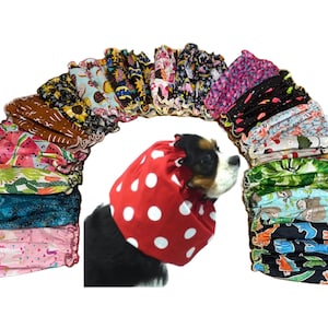 May include: A variety of pet recovery collars in assorted patterns, including floral, fruit, and animal prints. A dog is wearing a red collar with white polka dots. The collars are designed to prevent pets from licking wounds.