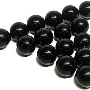 May include: A group of 18 black glass marbles.