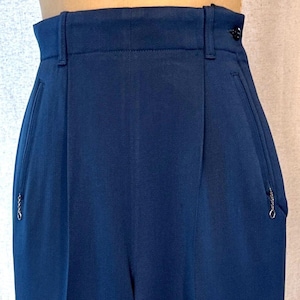 May include: A pair of dark blue high-waisted pants with a zippered pocket on each side.