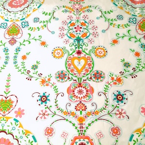 May include: White fabric with a repeating pattern of colorful flowers, hearts, and swirls. The pattern is intricate and detailed, with a variety of colors including pink, orange, yellow, green, and blue.