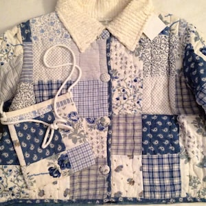 May include: A patchwork jacket and matching small purse in shades of blue and white. The jacket features a cream-colored corduroy collar and button closures. The purse has a white cord strap. The fabric is a mix of floral, paisley, and plaid patterns.