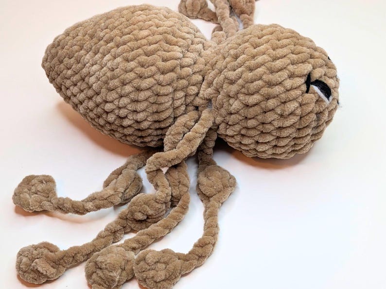 Side view of a crochet plush spider fidget toy. The side view highlights how long the legs are for pulling back and forth.