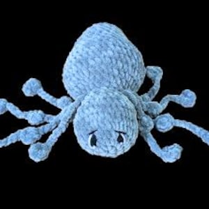A light grey crochet spider with long legs. The legs can be pulled back and forth to create a fidget toy.