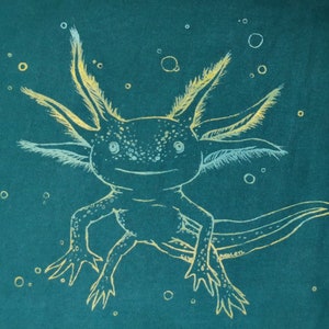 Könnte beinhalten: Ein weißer Axolotl mit gefiederten Kiemen, in Gelb und Weiß auf einem blaugrünen Hintergrund gezeichnet. Der Axolotl lächelt und hat große, runde Augen.