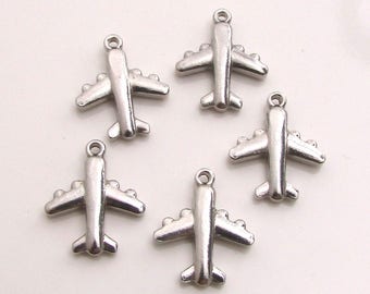 May include: Five silver airplane charms, each with a simple design. The charms are perfect for adding a travel theme to jewelry or crafts.