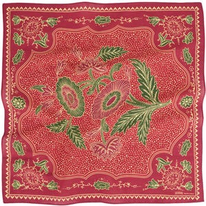 May include: A square, red bandana with a floral design. The bandana features a central floral arrangement in green and red, surrounded by a dotted background and a decorative border. The edges are finished with a detailed trim.