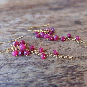 Brincos longos banhados a ouro com arruelas de rubi.