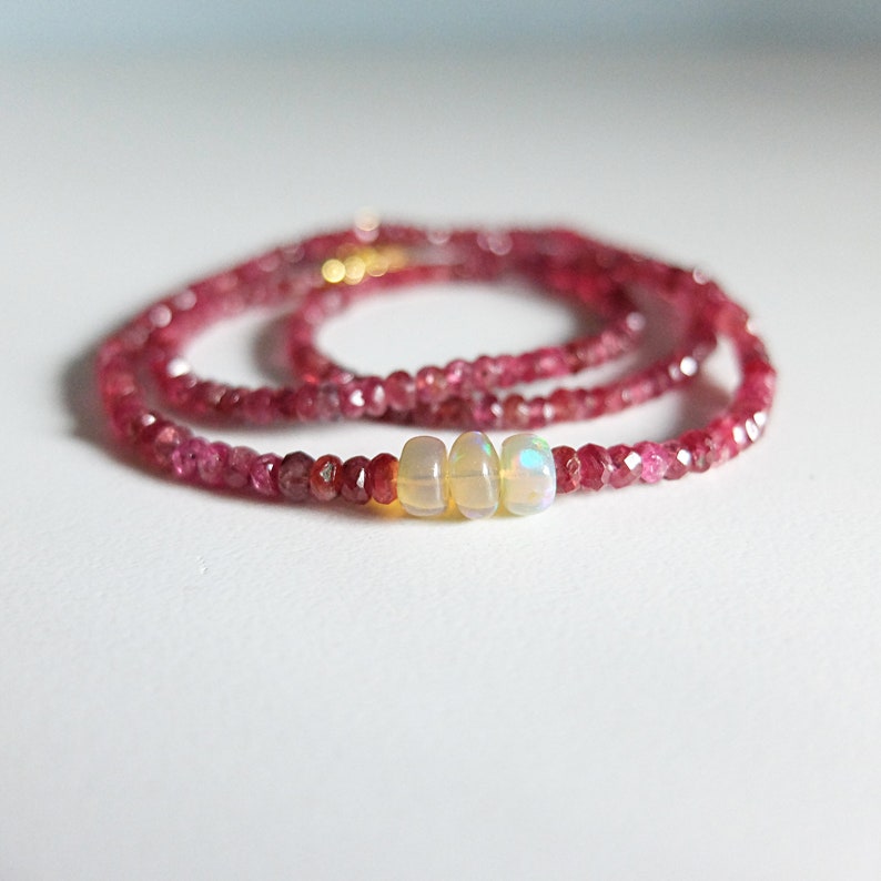 This is a beautiful classic layering pink ruby necklace! A Simple Authentic Ruby Necklace with a Marvelous colour
It is a strand of genuine, non treated , beautiful pink faceted ruby roundels, with 3 larger Opal gemstones in the center