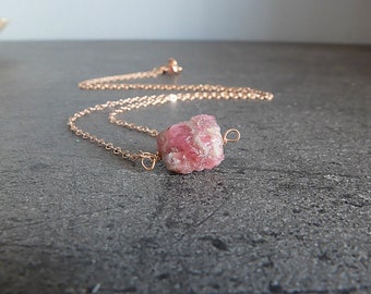 Könnte beinhalten: Eine zarte Halskette aus roségoldener Kette mit einem rohen rosa Kristall-Anhänger.