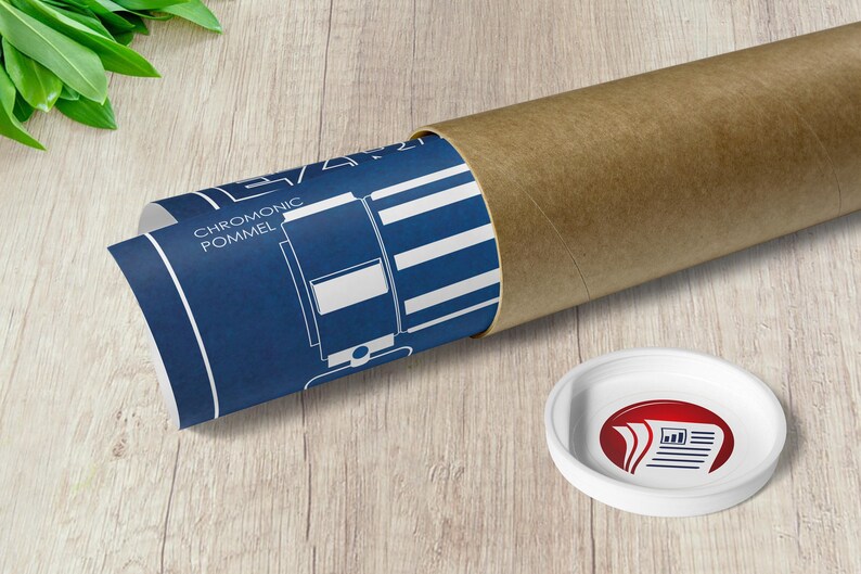 May include: A rolled up blue and white blueprint with the text "CHROMONIC POMMEL" is inside a brown cardboard tube. A white round sticker with a red logo of three stacked papers with a graph is on a wooden surface.