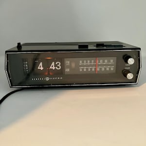 Radio despertador General Electric vintage de mediados de siglo, modelo C4331B, funcionando.