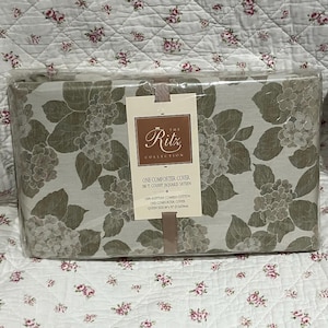 May include: A packaged comforter cover from The Ritz Collection. The cover features a floral pattern in shades of green and grey. The label indicates it is a queen size, 213 x 234 cm, made of Egyptian combed cotton.