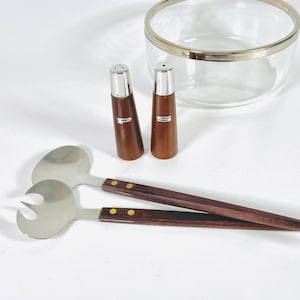 Può includere: Un set di due saliere e pepiere in legno con top argentati e un set di due posate per insalata in legno con dettagli dorati.