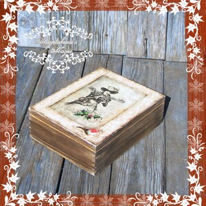 May include: A wooden box featuring a vintage-style image of a woman in a hat and a floral design. The box has a distressed brown finish and a white border around the image.