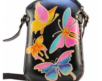 May include: Black leather crossbody bag with a zipper closure and a colorful butterfly design. The bag has a long adjustable strap.