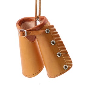 May include: A pair of brown leather wrist cuffs with a fringe detail and a buckle closure.