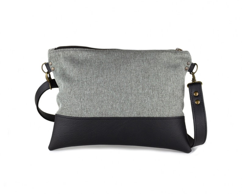 small light grey crossbody bag with hand-smocked pleated detail and black vegan leather bottom and adjustable strap; back view (without pleated detail)