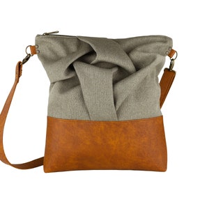 brown medium-sized crossbody bag with hand-smocked pleated detail and brown vegan leather bottom and adjustable strap; front view