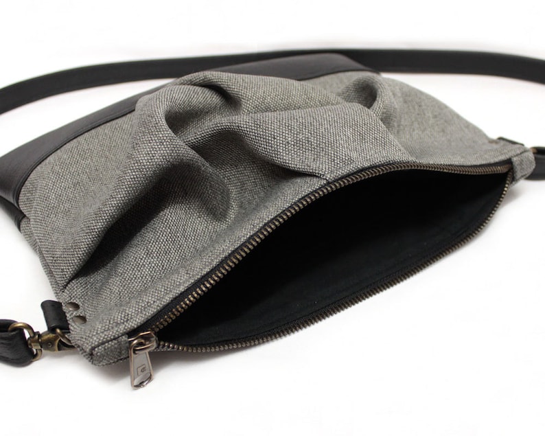 small light grey crossbody bag with hand-smocked pleated detail and black vegan leather bottom and adjustable strap; open