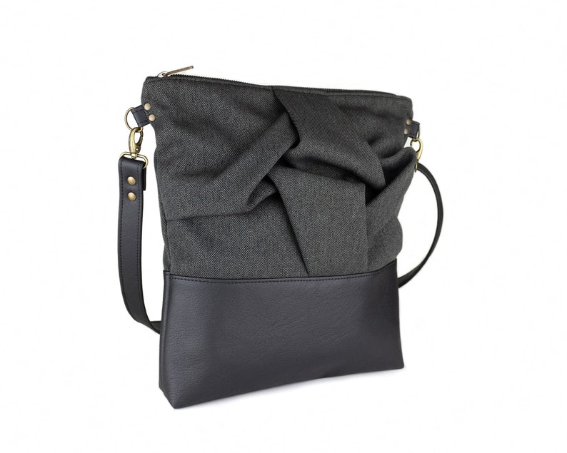 charcoal black medium-sized crossbody bag with hand-smocked pleated detail and  black vegan leather bottom and adjustable strap; side view