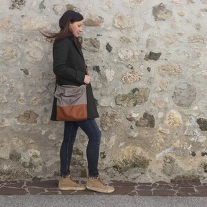 a woman wearing the medium-sized crossbody bag in front of a wall