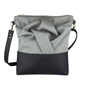 gray medium-sized crossbody bag with hand-smocked pleated detail and  black vegan leather bottom and adjustable strap; front view