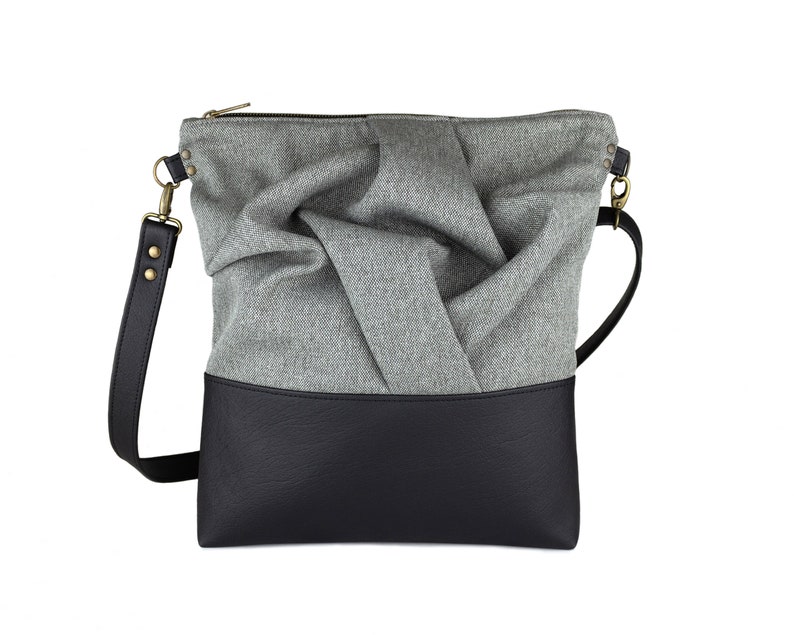 gray medium-sized crossbody bag with hand-smocked pleated detail and  black vegan leather bottom and adjustable strap; front view