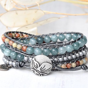 May include: A multi-strand leather wrap bracelet with turquoise and brown beads, a silver charm, and a silver heart charm.