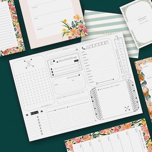 Può includere: Una collezione di articoli di cancelleria, tra cui un grande planner bianco con testo e grafica neri, circondato da biglietti a motivi floreali e a righe. Il planner presenta sezioni per attività quotidiane, contatti e promemoria. La tavolozza dei colori comprende bianco, nero, rosa e accenti floreali.