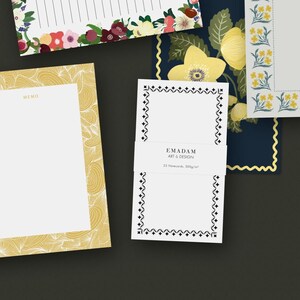 May include: Selection of stationery items with floral and geometric patterns. Includes memo pads, notecards, and lined paper. The notecards have a black and white diamond border and the text "EMADAM ART & DESIGN".