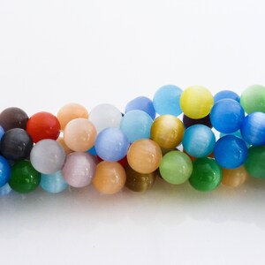 May include: A strand of colorful round beads with a variety of colors including blue, green, yellow, pink, and orange.