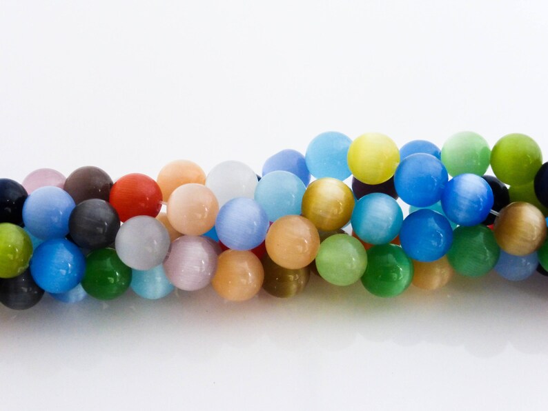 May include: A strand of colorful round beads with a variety of colors including blue, green, yellow, pink, and orange.