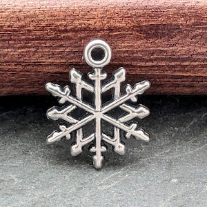 Pode incluir: Encanto de floco de neve prateado com um laço na parte superior para anexar a joias ou outros artesanatos.