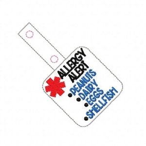 Può includere: Un'etichetta quadrata bianca con un simbolo medico rosso e il testo "Allergy Alert" in nero. Sotto il simbolo ci sono le parole "Peanuts", "Dairy", "Eggs" e "Shellfish" in blu.
