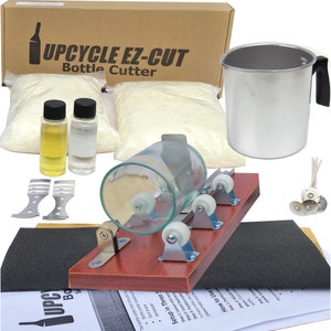May include: A complete DIY upcycle kit with the text "UPCYCLE EZ-CUT Bottle Cutter". The kit includes a bottle cutter, a stainless steel pitcher, wax, wicks, and other supplies for crafting. The kit also includes instructions.