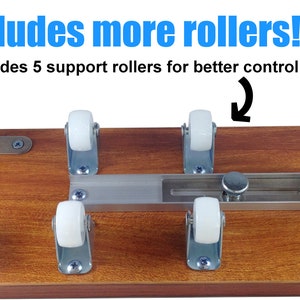 Puede incluir: Base de madera con marco met&aacute;lico y cinco rodillos blancos. El texto "Includes more rollers!" y "Includes 5 support rollers for better control" se muestra en azul y negro.