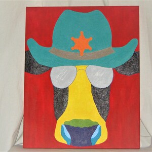May include: A painting of a cow wearing a turquoise cowboy hat with a silver star and sunglasses. The cow's face is yellow with a green and blue nose. The background is red.