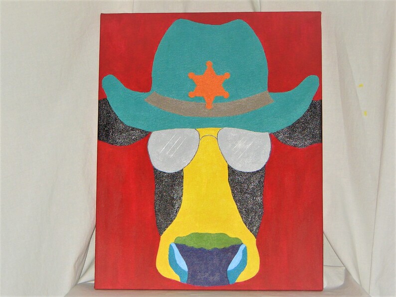 May include: A painting of a cow wearing a turquoise cowboy hat with a silver star and sunglasses. The cow's face is yellow with a green and blue nose. The background is red.