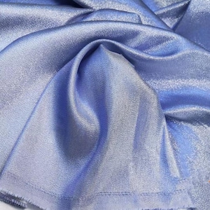 May include: A close-up of a light blue fabric with a subtle shimmer. The fabric has a smooth, silky texture and a slightly textured surface.