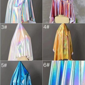 May include: Six samples of iridescent fabric in different colors. The fabric is draped over a white mannequin form. The colors are silver, pink, white, gold, blue, and teal.