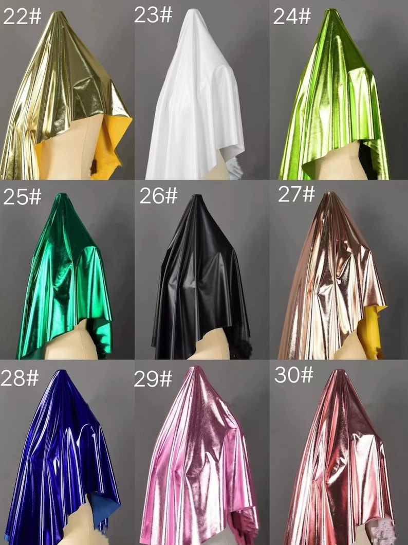May include: Nine samples of metallic fabric in different colors, including gold, white, green, black, rose gold, pink, and blue. Each fabric sample is draped over a mannequin head.