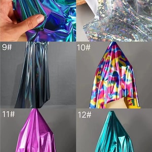 May include: A collection of iridescent fabric samples in various colors, including teal, purple, pink, and blue. The fabric has a shiny, metallic finish.
