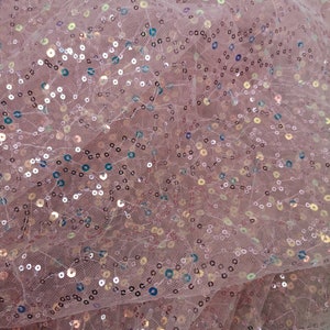 May include: Pink sheer fabric with iridescent sequins. The sequins are scattered randomly across the fabric.