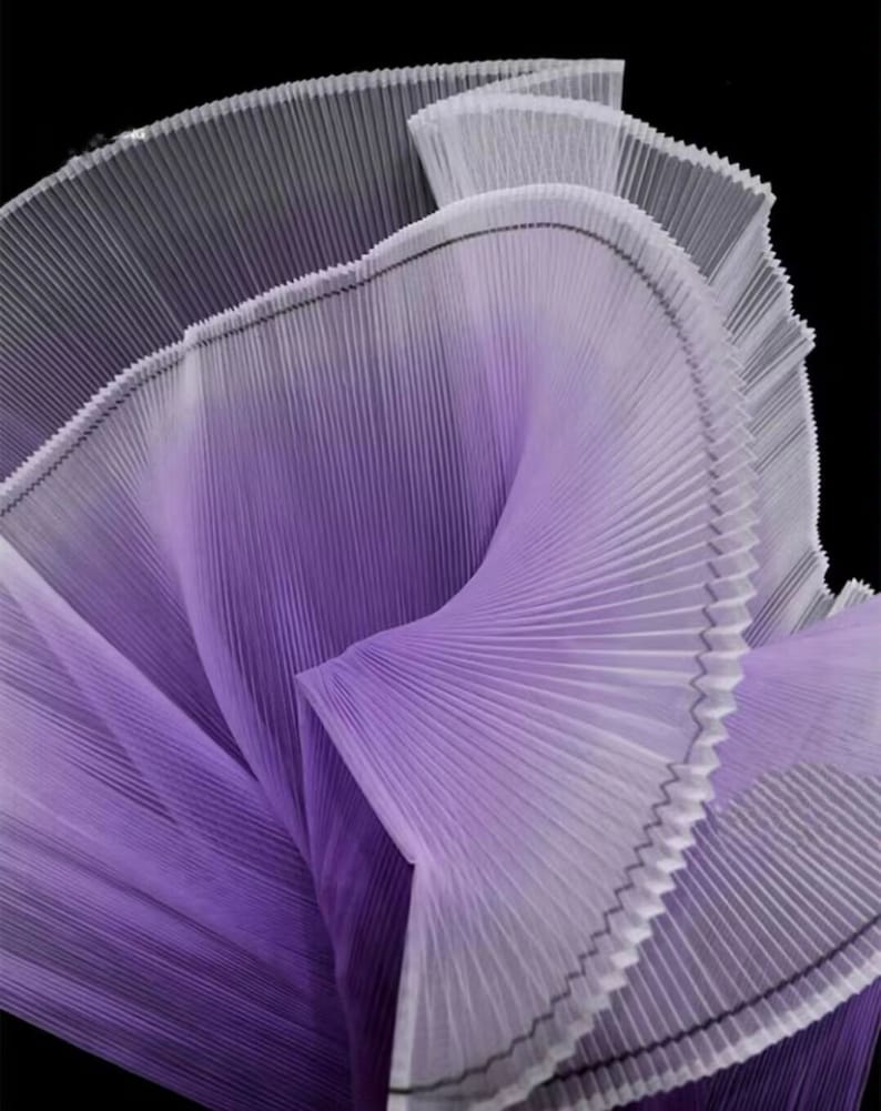 Peut inclure: Un gros plan sur un tissu pliss&eacute; violet et blanc. Le tissu est pli&eacute; et drap&eacute; de mani&egrave;re &agrave; cr&eacute;er un motif abstrait tourbillonnant.