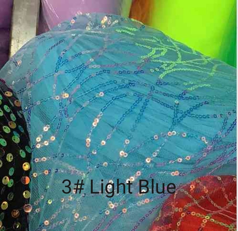 May include: Light blue tulle fabric with iridescent sequins in a geometric pattern. The fabric is labeled "3# Light Blue".