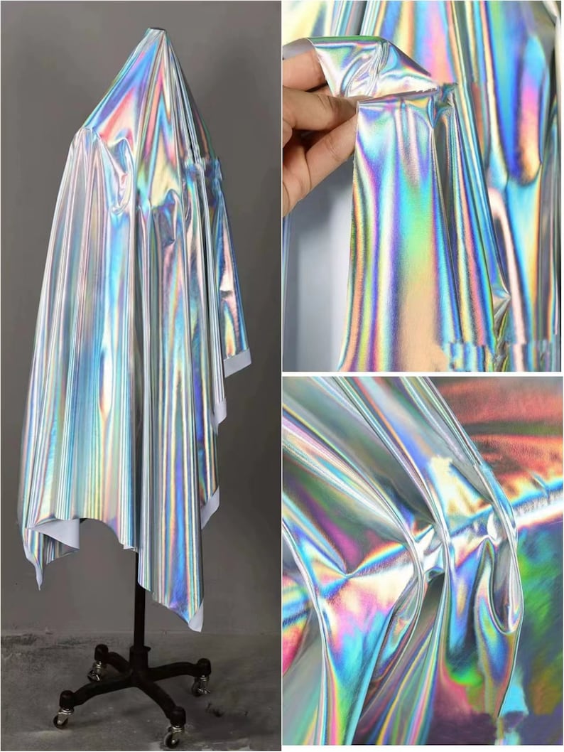 May include: A silver iridescent fabric with a holographic finish. The fabric is draped over a mannequin and shows the texture and sheen of the material.